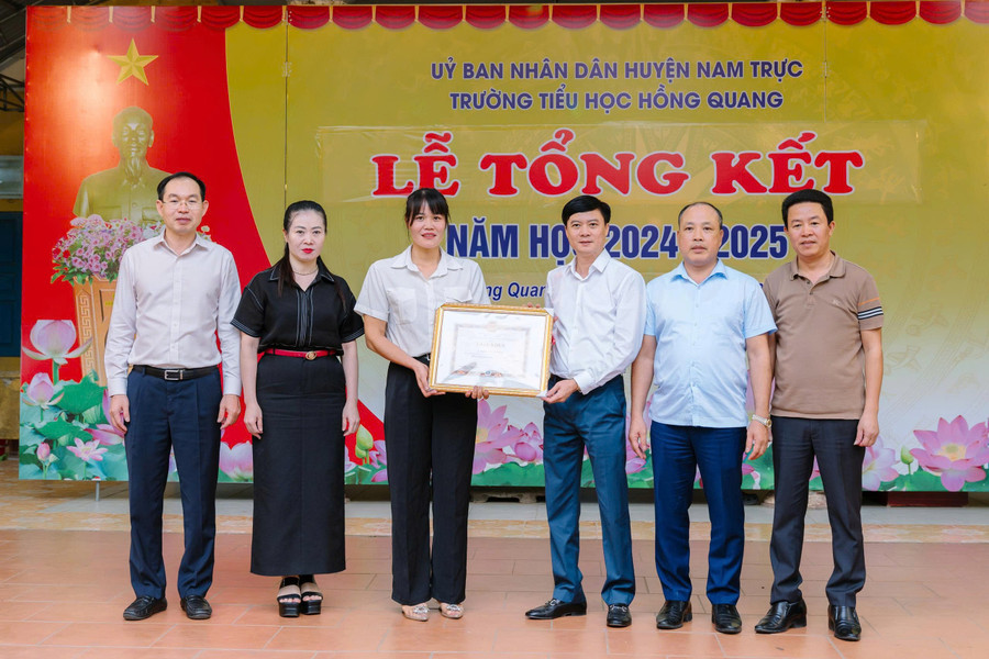 Giám đốc Sở GD&ĐT Nam Định Nguyễn Xuân Hồng trao Giấy khen cho hành động dũng cảm cứu người của cô Nguyễn Thị Mai. Ảnh: Nhà trường cung cấp. 