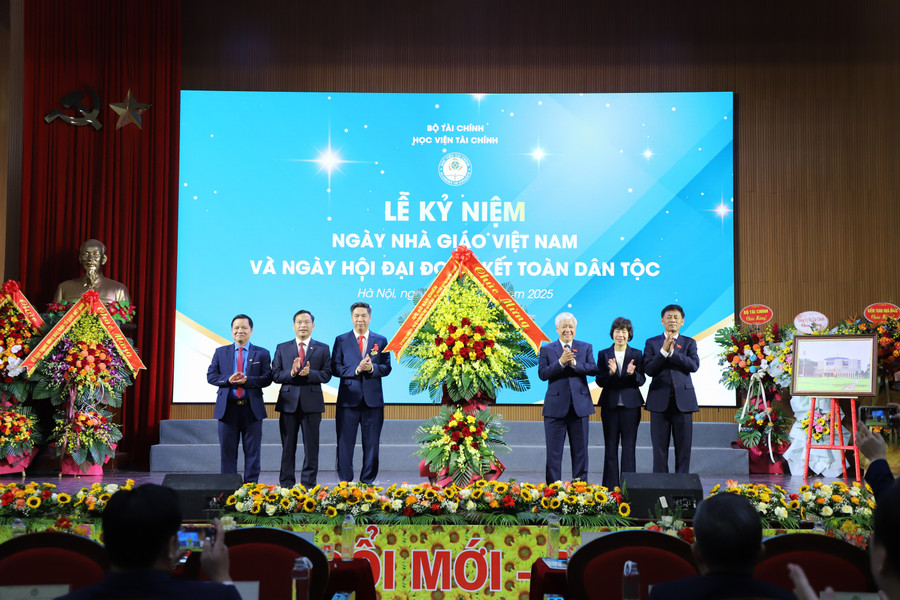 Phó Chủ tịch Quốc hội Đỗ Văn Chiến tặng hoa chúc mừng Học viện Tài chính tại chương trình. 