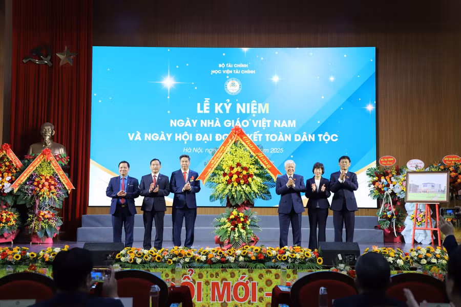 Phó Chủ tịch Quốc hội Đỗ Văn Chiến tặng hoa chúc mừng Học viện Tài chính tại chương trình. 
