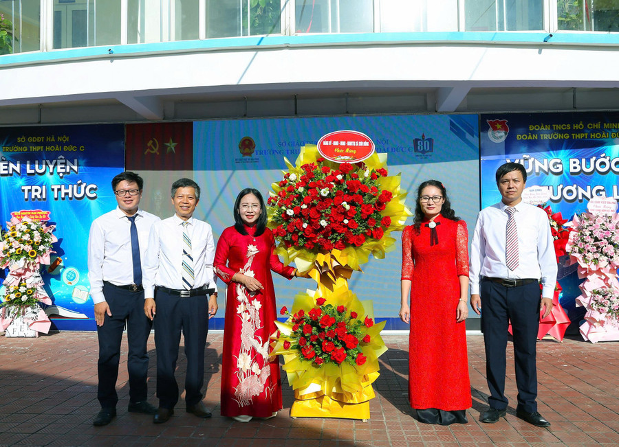 Bà Nguyễn Thị Thanh (thứ hai từ phải qua) - Thường vụ Đảng ủy, Chủ tịch Ủy ban Mặt trận Tổ quốc Việt Nam xã Sơn Đồng tặng hoa chúc mừng nhà trường nhân dịp khai giảng năm học mới. 