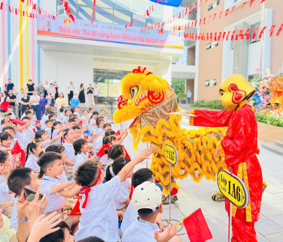 Các em học sinh khối 1 hào hứng với chú lân tại lễ khai giảng. mo-1.jpg