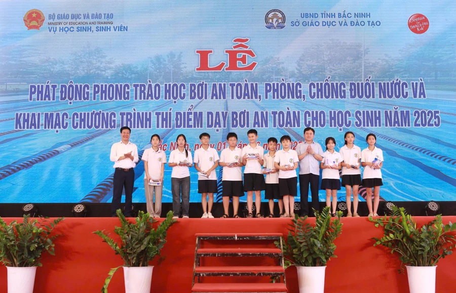Ban tổ chức trao tặng quà cho các em học sinh tham gia thí điểm chương trình học bơi an toàn tại tỉnh Bắc Ninh. 
