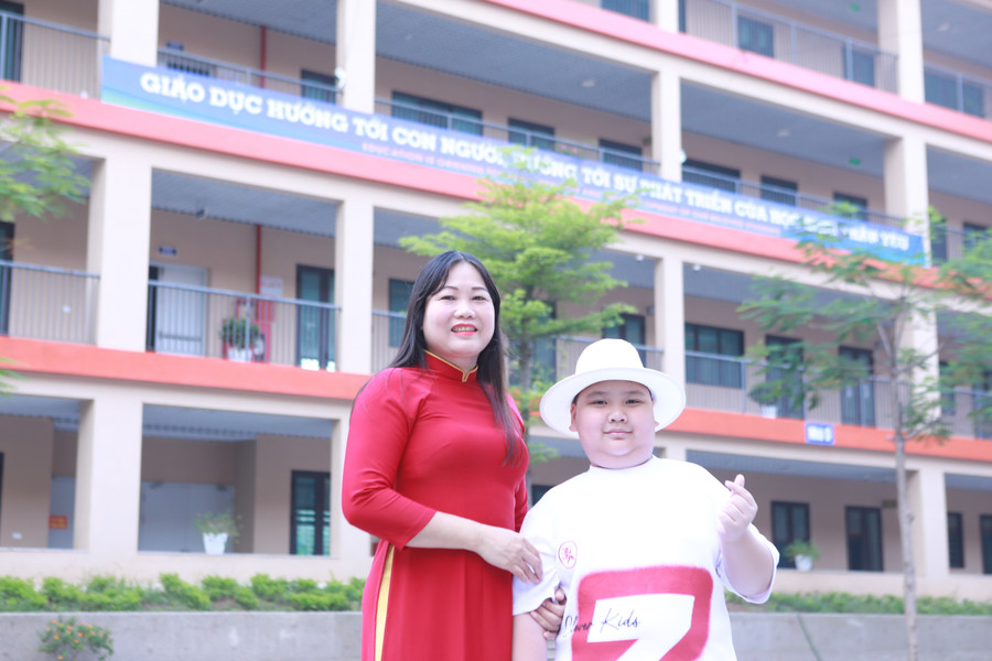Hiệu trưởng Trường THCS Tây Mỗ 3 Vũ Thị Thìn chào đón học sinh Bùi Nguyên Gia Bảo sau khi hoàn thiện hồ sơ đăng ký tuyển sinh vào lớp 6 năm nay. Ảnh: Đình Tuệ. 3.jpg