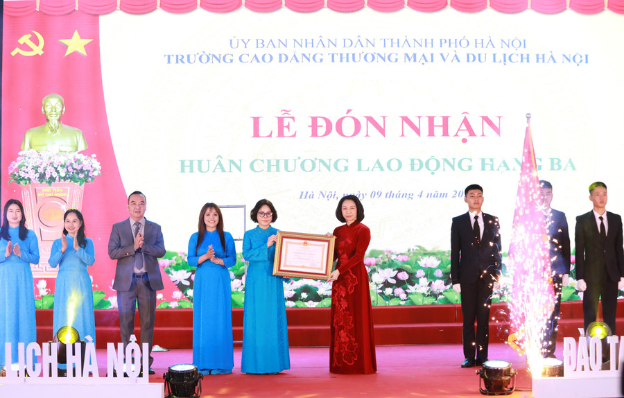 TS Trịnh Thị Thu Hà (thứ 5 từ trái sang) thay mặt lãnh đạo nhà trường đón nhận Huân chương Lao động hạng Ba của Chủ tịch nước từ Phó Chủ tịch UBND TP Hà Nội Vũ Thu Hà. Ảnh: Đình Tuệ.