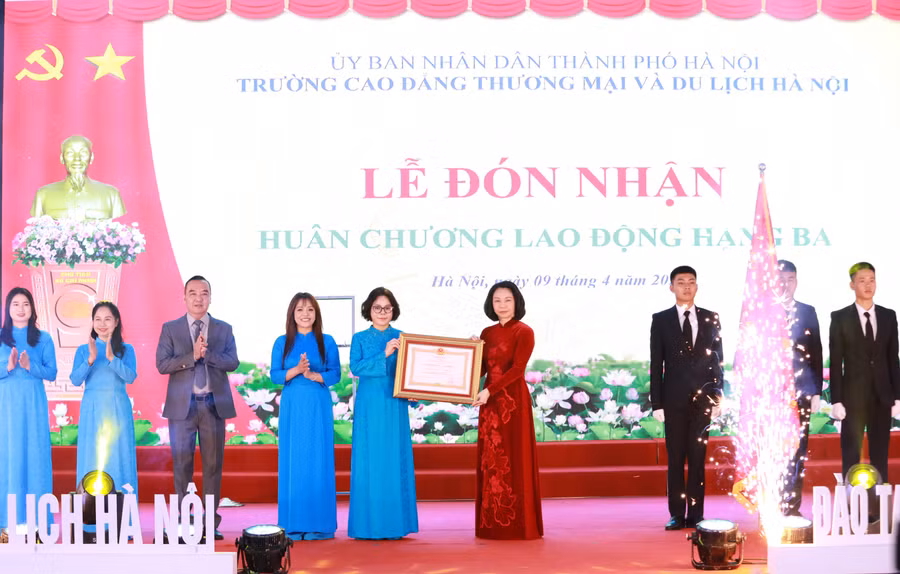 TS Trịnh Thị Thu Hà (thứ 5 từ trái sang) thay mặt lãnh đạo nhà trường đón nhận Huân chương Lao động hạng Ba của Chủ tịch nước từ Phó Chủ tịch UBND TP Hà Nội Vũ Thu Hà. Ảnh: Đình Tuệ.