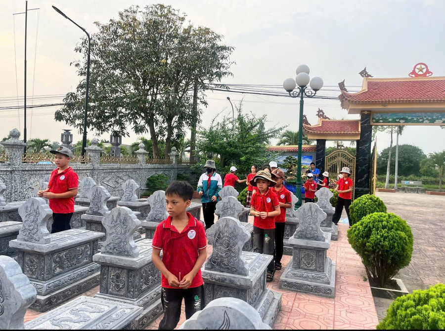 Các em học sinh xã Hải Xuân (Ninh Bình) tham gia dọn dẹp vệ sinh tại các nghĩa trang liệt sĩ trên địa bàn xã trong dịp ngày 27/7. 