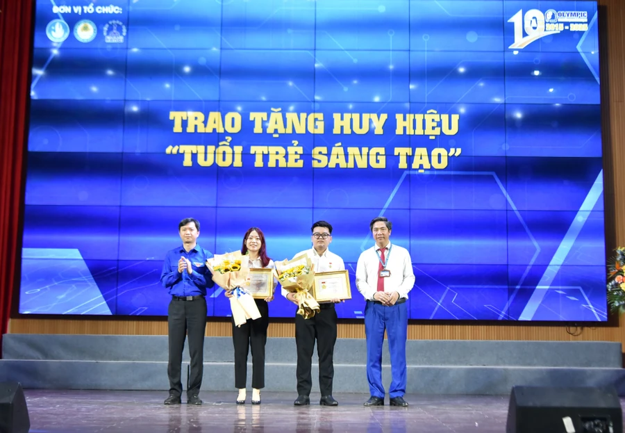 Anh Nguyễn Minh Triết (bìa trái) - Bí thư Trung ương Đoàn, Chủ tịch Trung ương Hội Sinh viên Việt Nam và Giám đốc Học viện Tài chính Nguyễn Đào Tùng trao tặng huy hiệu "Tuổi trẻ sáng tạo" cho hai sinh viên xuất sắc. 