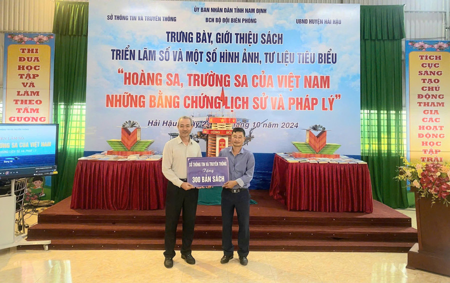 Ông Nguyễn Hải Sơn (phải) - Hiệu trưởng Trường THCS Hải Xuân tiếp nhận sách cho thư viện nhà trường. Ảnh: NTCC. hai-xuna-5.jpg