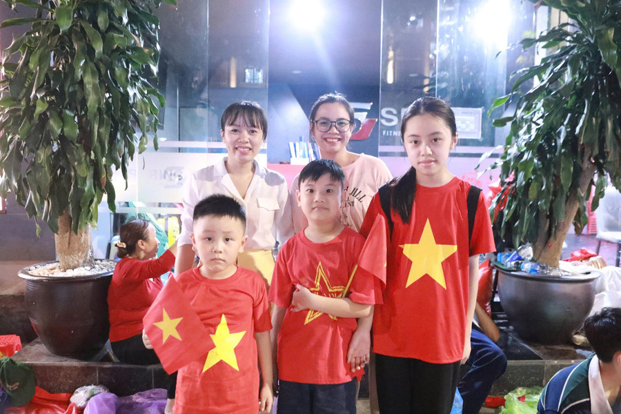Chị Huế (trái) và người thân háo hức đón chờ được xem diễu binh như "đón giao thừa" ngay tại cổng Công viên Thống Nhất, Hà Nội. Ảnh: Đình Tuệ. t8.jpg