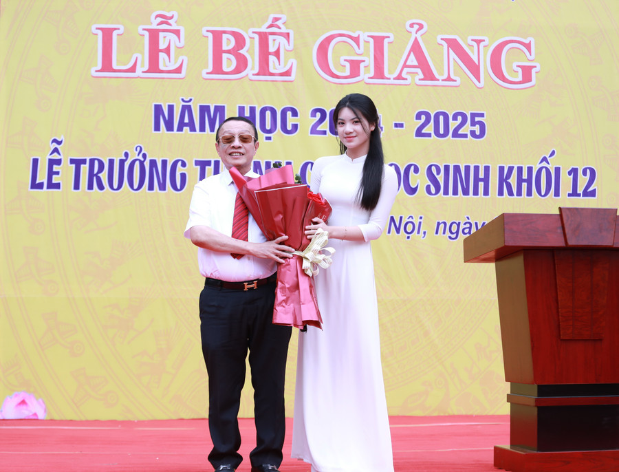 Đại diện học sinh nhà trường trao tặng bó hoa tươi thắm thay cho lời tri ân gửi tới TS Lê Xuân Trung - Hiệu trưởng Trường THPT Lê Lợi. 2.jpg