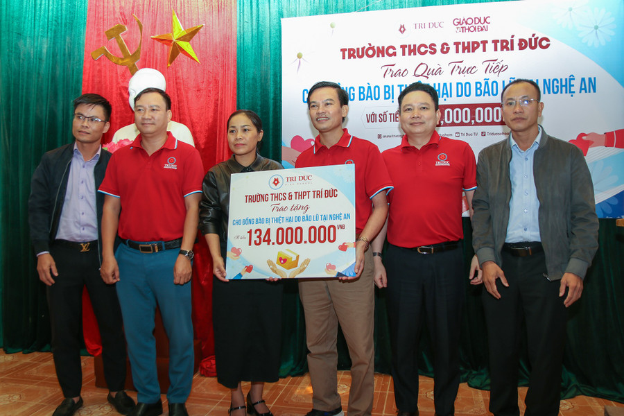 Đại diện UBMTTQ xã Tân Kỳ tiếp nhận phần quà của Trường THCS & THPT Trí Đức. img-9694.jpg