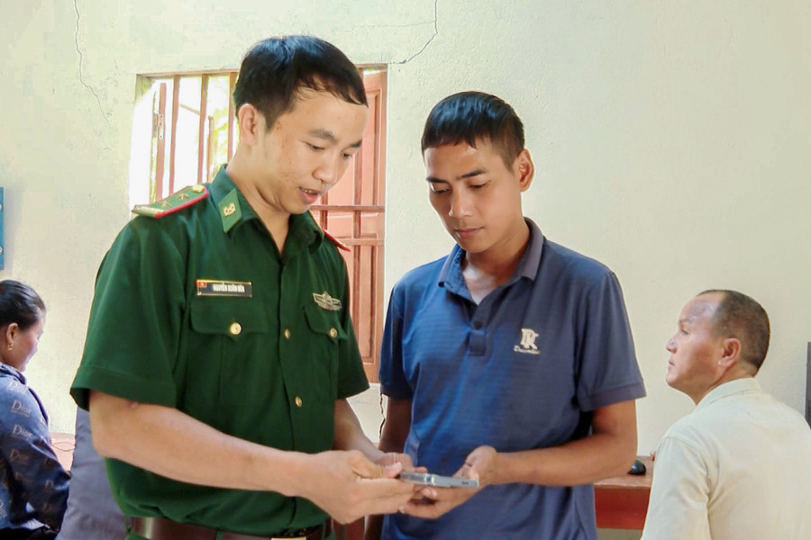 Cán bộ Biên phòng hướng dẫn người dân sử dụng ứng dụng VNeID. (Ảnh: Hải Thượng)