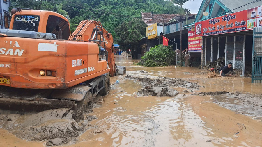 Sau lũ, cây cối mắc ngổn ngang trên các tuyến đường, bùn đất có nơi ngập đến hơn 50cm khiến việc đi lại gặp nhiều khó khăn. Chính quyền địa phương phải huy động máy múc để cào bùn đất. fb-img-1753250367809.jpg