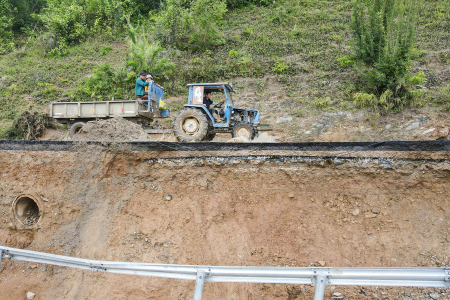 Nền đường bị sạt lở cao hơn 10m, từng mảng bê tông nhựa, lan can đường rơi xuống sông Lam. quoc-lo-7-8.jpg