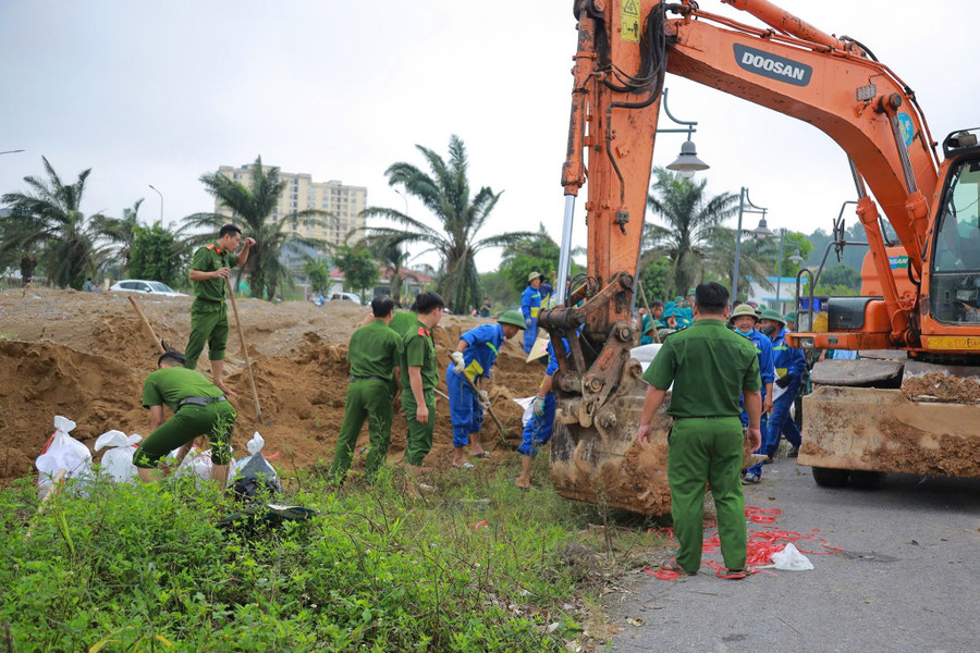Hàng trăm cán bộ, chiến sĩ công an, quân đội, dân quân tự vệ cùng các phương tiện, máy móc được huy động đến hiện trường. de-song-vinh-5.jpg