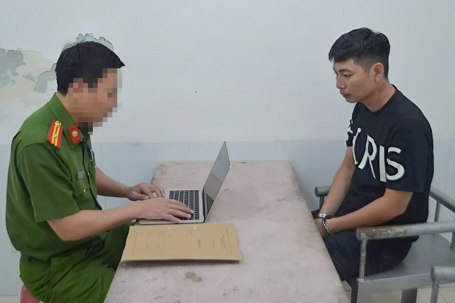 Công an lấy lời khai của Bàn Văn Vỹ. (Ảnh: CANA)