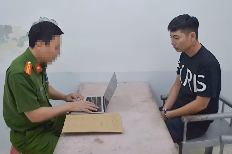 Công an lấy lời khai của Bàn Văn Vỹ. (Ảnh: CANA)