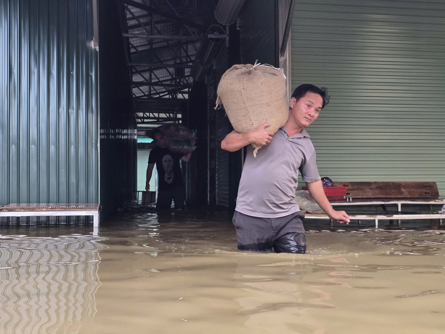 Sáng 1/10, nước sông Vinh tiếp tục dâng cao nên nước khu vực chợ vẫn chưa rút, bà Lan phải nhờ người thân hỗ trợ di dời hàng hóa ra ngoài để tránh bị ngập, hư hỏng. cho-vinh-8.jpg