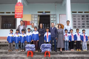 Ông Nguyễn Minh Hiệu (hàng đầu, thứ 6 tính từ bên phải) trao tặng áo ấm và chụp ảnh lưu niệm cùng cô trò nhà trường.
