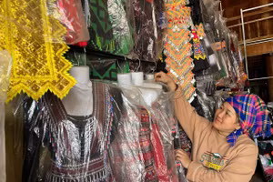 Chị Giàng Thị Lan sắp xếp lại các bộ trang phục dân tộc đón khách mua hàng.