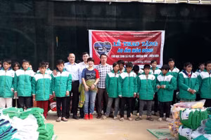 Bà Dương Thanh Hương - Phó Tổng Biên tập Báo Giáo dục và Thời đại (thứ 8 từ trái sang) cùng đại diện Quỹ hỗ trợ giáo dục NTS-KASPERSKY trao quà cho học sinh xã Pá Mỳ, huyện Mường Nhé cũ.