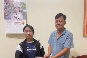 Thầy Phạm Ngọc Nguyễn (bên phải) trao trả lại ví kèm tài sản, giấy tờ tùy thân cho người đánh rơi tại trụ sở Công an xã Mường Nhé.