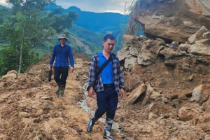 Anh Lê Trung Kiên (đi sau) cùng ê kíp của Đài Phát thanh -Truyền hình Lào Cai di chuyển đến Làng Nủ sau thảm họa để tác nghiệp.