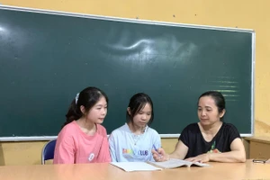 Cô Vũ Thị Kim Tuyến (ngoài cùng bên phải) trao đổi bài với học sinh. (Ảnh: Trường PTDTNT THPT tỉnh Điện Biên)