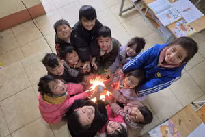 Học sinh Sa Pa quây quần quanh đèn sưởi trong giờ ra chơi tại lớp.