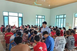 Ông Nguyễn Văn Tập kiểm tra bữa ăn của học sinh.