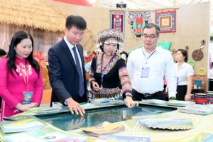 Ông Trần Huy Tuấn - Chủ tịch UBND tỉnh Lào Cai (thứ 2 bên trái) tham quan gian hàng tại triển lãm.