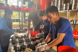 Nhân viên nhà bếp Trường PTDTNT THPT Mường Nhé chia thức ăn cho học sinh.