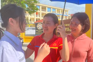 Cô Tô Thị Thịnh (đứng giữa) cùng đồng nghiệp trao đổi kết quả bài thi với học trò.