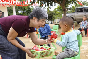 Nhà báo Dương Thanh Hương - Phó Tổng Biên tập Báo Giáo dục và Thời đại trao quà động viên học sinh nghèo xã Tìa Dình, tỉnh Điện Biên.