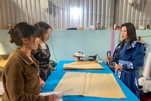 Chị Giàng Thị Mỷ (bên phải) hướng dẫn các học viên học nghề may.