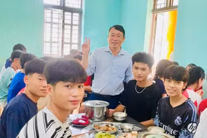 Ông Cà Văn Minh - Hiệu trưởng Trường PTDTNT THPT Mường Ảng (đứng giữa) động viên học sinh trong bữa cơm tập thể.