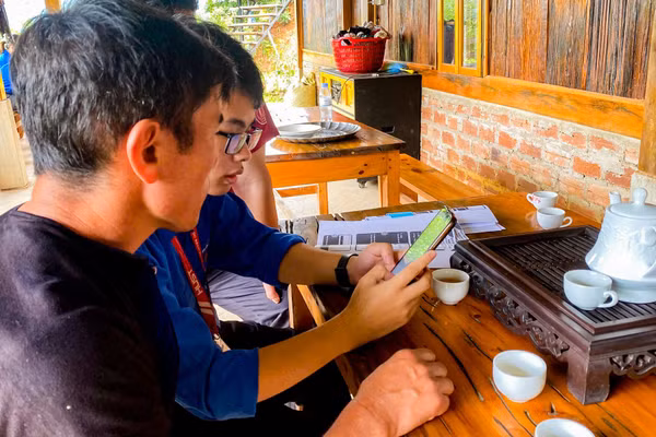 Sinh viên Khoa Khoa học và Công nghệ Giáo dục, Đại học Bách khoa Hà Nội hướng dẫn người dân ứng dụng công nghệ vào quản lý homestay và quảng bá văn hoá, du lịch địa phương.