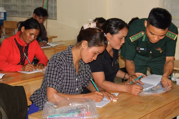 Đại úy Hồ Văn Hữu, Đội trưởng Vận động quần chúng, Đồn Biên phòng Ba Tầng, Ban Chỉ huy Bộ đội Biên phòng tỉnh Quảng Trị hướng dẫn học viên lớp xoá mù chữ. Ảnh NVCC.