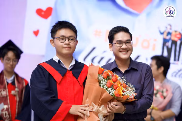 Thạc sĩ Võ Minh Nghĩa (bên phải) cùng học sinh.