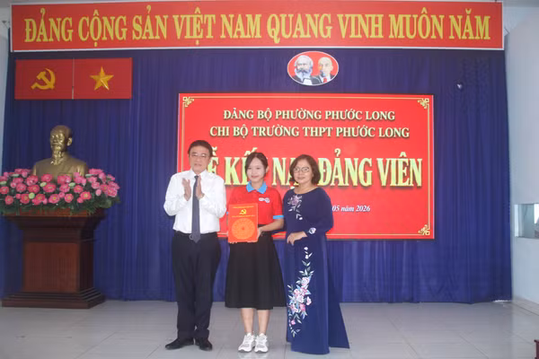 Ông Liên Minh Thiện, Trưởng ban Xây dựng Đảng phường Phước Long và bà Vũ Thị Hồng Châu trao quyết định kết nạp cho đảng viên Trần Bảo Nhiên.