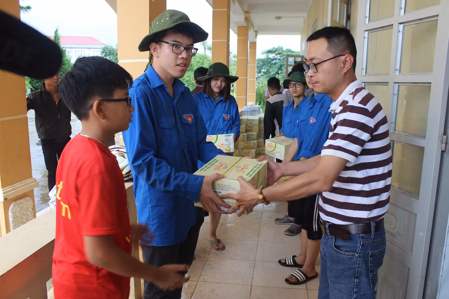 Chung tay chuyển quà vào bên trong hội trường để trao cho bà con Chung tay chuyển quà vào bên trong hội trường để trao cho bà con