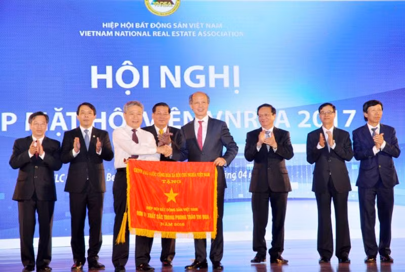 Thứ trưởng Bùi Phạm Khánh trao cờ thi đua của Chính phủ cho Hiệp hội BĐS Việt Nam.