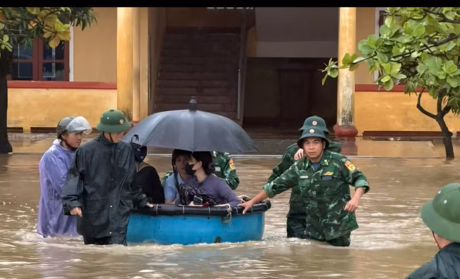 Cán bộ, chiến sĩ Bộ đội Biên phòng Hà Tĩnh dùng thuyền thúng đưa giáo viên và học sinh đến nơi an toàn.