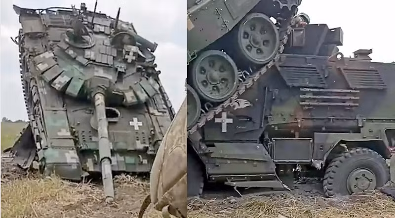 Hình ảnh được ghi lại hôm 22/6 cho thấy binh sĩ nước này đi ngang qua xe tăng T-72B3 nằm bất động khi đè lên chiếc MRAP MaxxPro. Hình ảnh T-72 cắm đầu xuống đất khi cố chèn qua MRAP