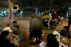 Cư dân quây quần luộc bánh chưng ngay vỉa hè chung cư ở Hà Nội