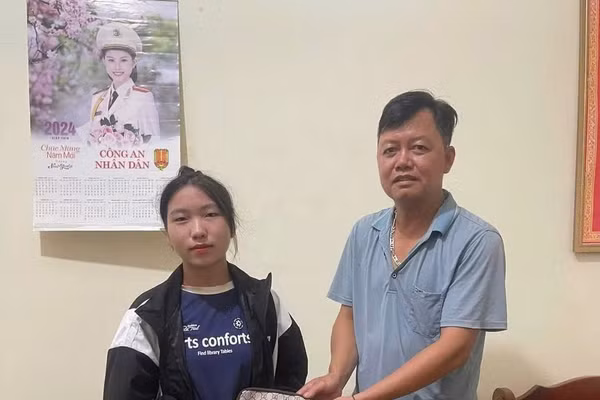Thầy Phạm Ngọc Nguyễn (bên phải) trao trả lại ví kèm tài sản, giấy tờ tùy thân cho người đánh rơi tại trụ sở Công an xã Mường Nhé.