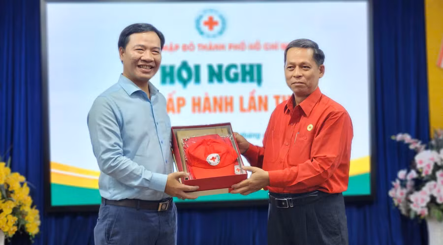 Ông Nguyễn Minh Nhựt (trái) nhận quà của Hội Chữ thập đỏ TPHCM.