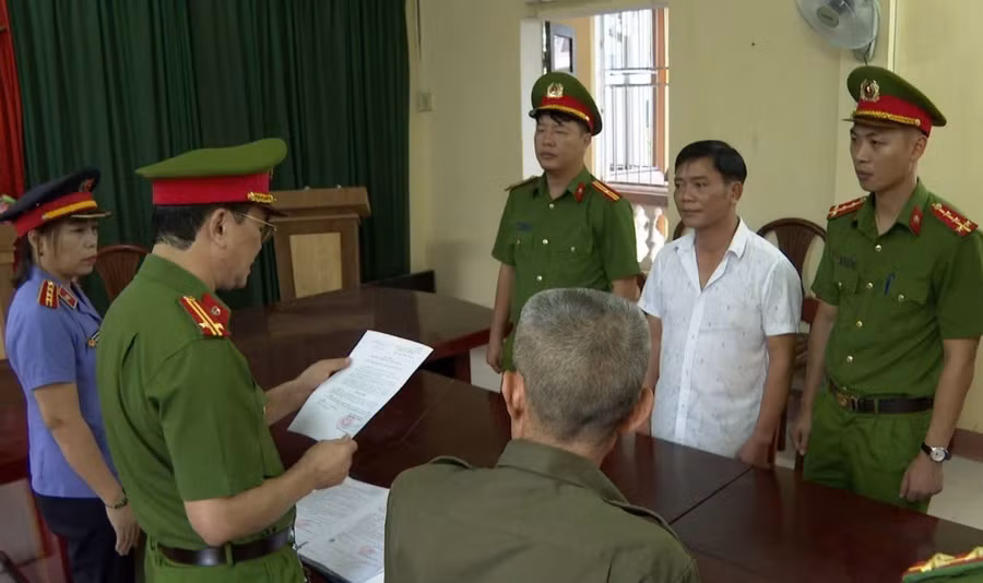 Cơ quan điều tra tống đạt các quyết định đối với Nguyễn Thế Bảo (áo trắng).