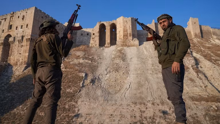 Chiến binh đối lập Syria chụp ảnh trước thành cổ Aleppo sau khi giành quyền kiểm soát thành phố Syria này ngày 1/12. Ảnh: Karam Almasri/Getty Images