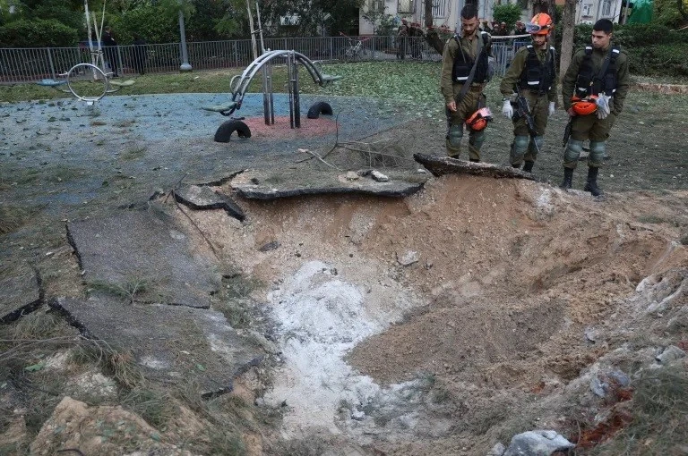 Nhân viên an ninh Israel kiểm tra một miệng hố tại địa điểm một quả đạn pháo bắn từ Yemen rơi xuống Tel Aviv, Israel sáng 21/12. Ảnh: Jack Guez/AFP.